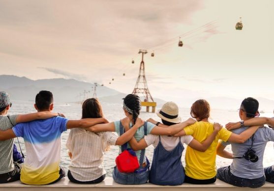 people holding shoulders sitting on wall